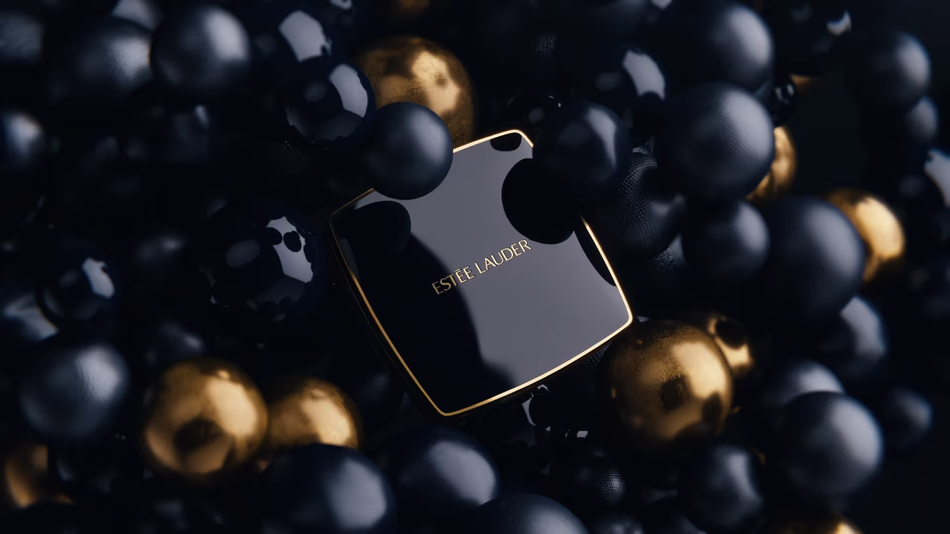 Estee Lauder Craftsmanship campaign still, black gloss case surrounded by metallic bubbles